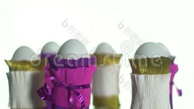 白色和紫色包裹的鸡蛋在展示桌上旋转